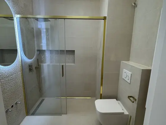 Fürdőszoba walk-in zuhannyal és arany szerelvényekkel – TeleHome felújítás referencia