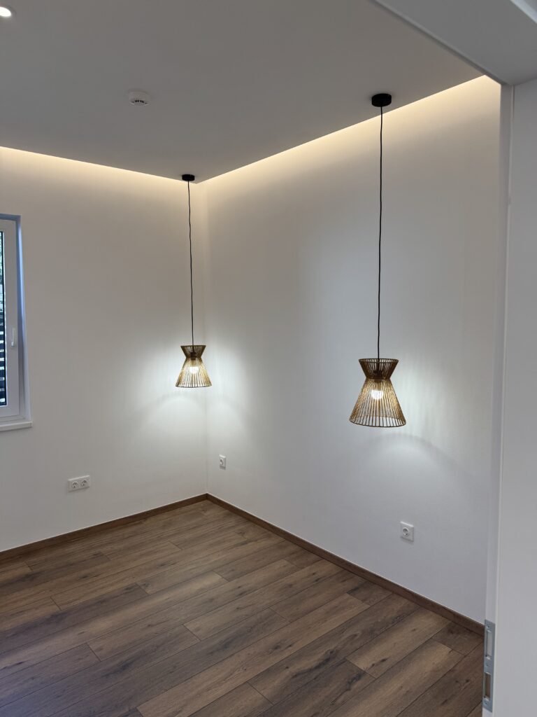 Felújított szoba glettelés és festés után, modern villanyszerelés megoldásokkal