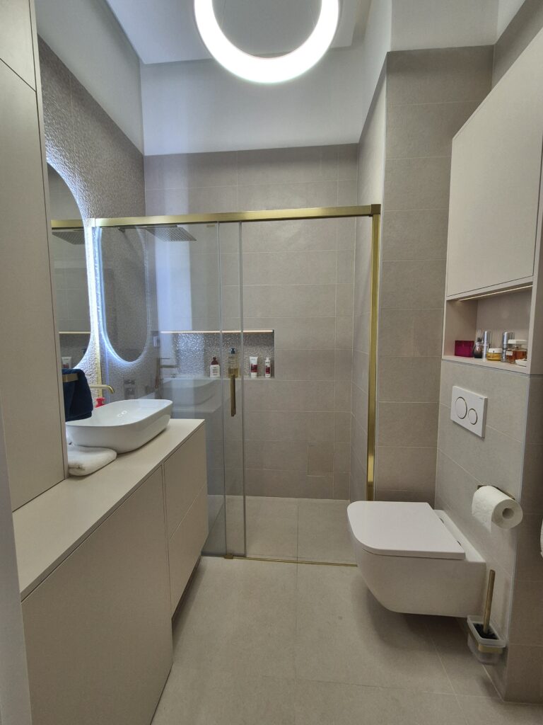 Felújított fürdőszoba modern csempe burkolattal, letisztult fürdőszoba szekrény megoldással és időtálló fürdőszoba csempe kialakítással, amely egységes és prémium megjelenést ad a térnek.