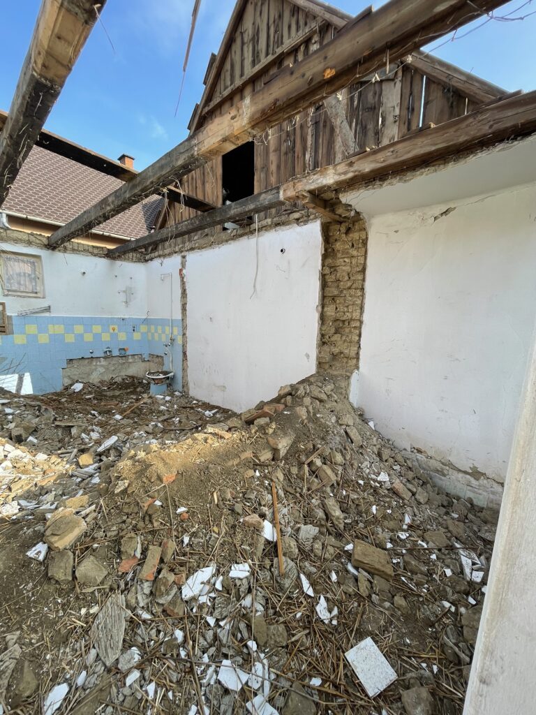 Egy ház bontása a családi ház felújítás előkészítéseként, ahol a bontás árak és a kivitelezési folyamat jól érzékelhető.