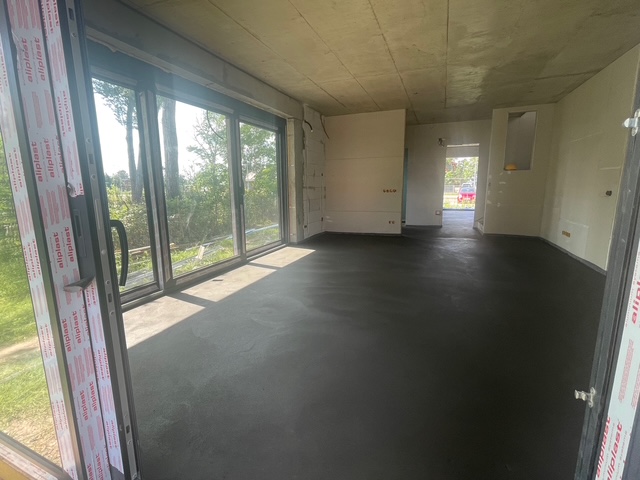 Egy tágas szoba betonozás, és burkolás után.