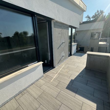 Egy falrész burkolás és vakolás után. Új nyílászárók.